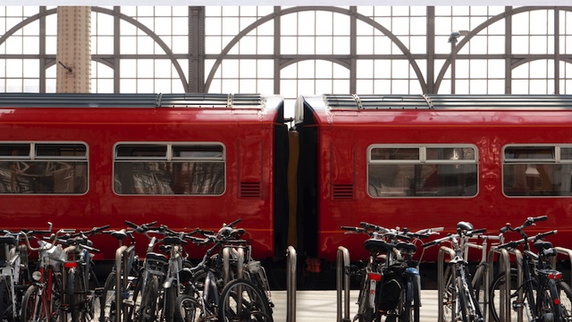 Exploring different modes of budget public transportation for families while traveling, featuring bicycles parked in front of a train station.