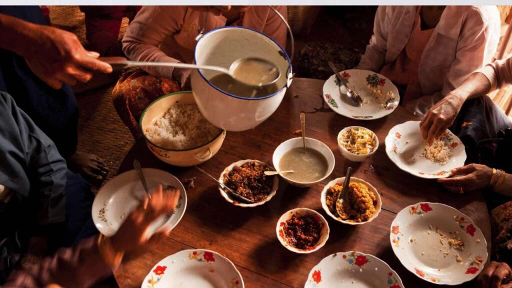 Family meal while traveling on a budget, sharing food around a table.