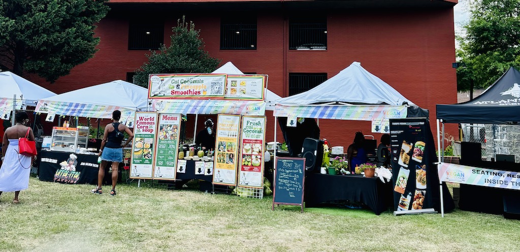 Vendor stands offering various vegan products at the Vegan Street Fair in Atlanta.