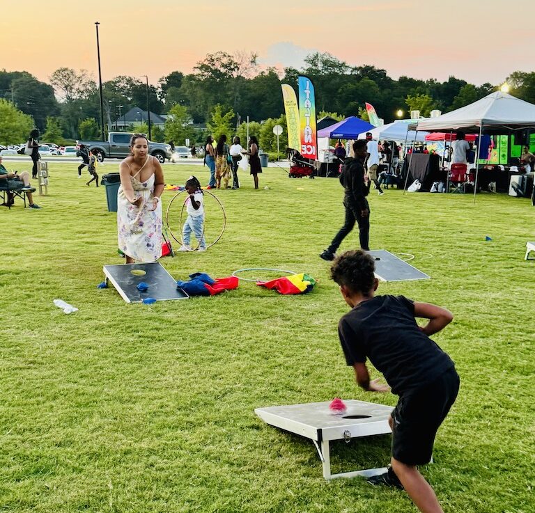 Kids playing cornhole at Stockbridge event