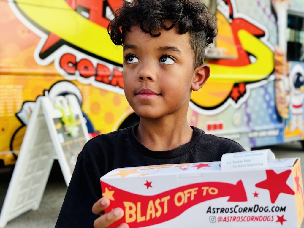 Child holding Astros Corn Dogs at Stockbridge event