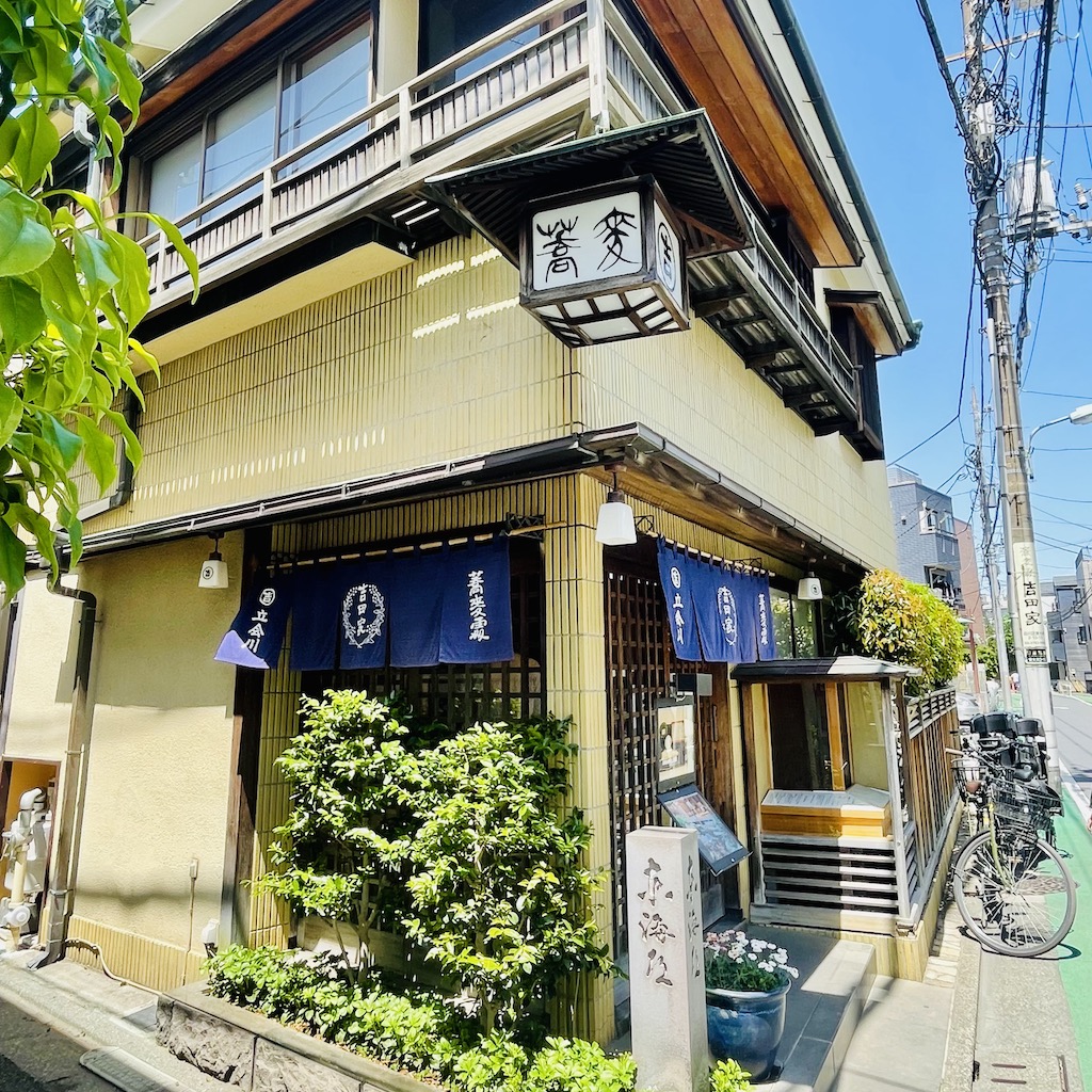 Exterior of a traditional Japanese inn (ryokan) in a quiet neighborhood.