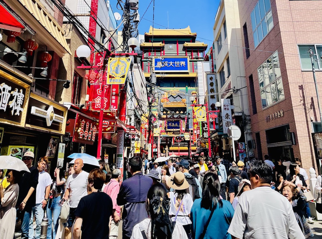 Busy street in Yokohama Chinatown filled with vibrant signs and people.