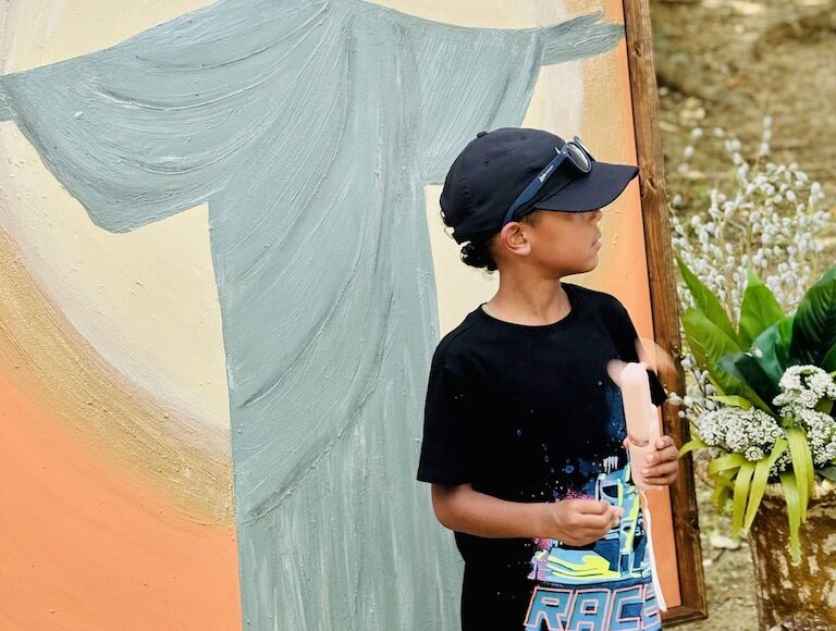 Boy cooling off with a handheld fan at the Piedmont Park Arts Festival.