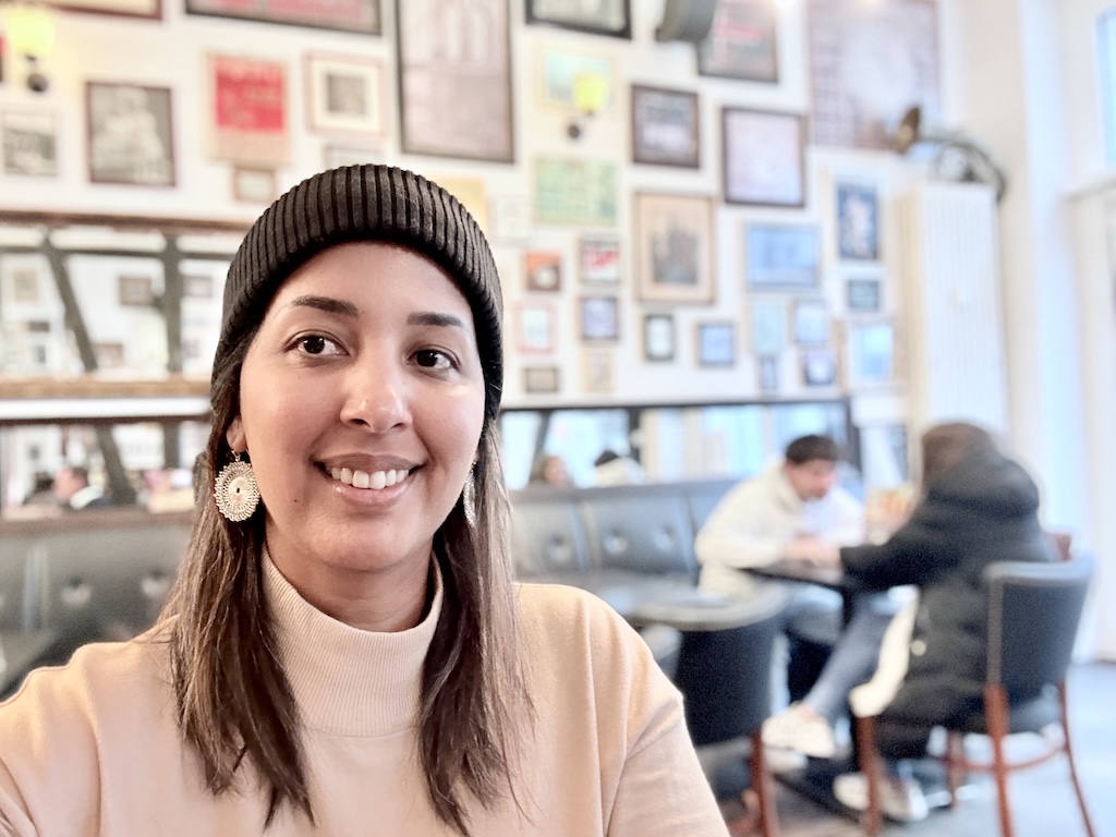 Smiling woman enjoying coffee at Kaffee Klatsch in Bad Homburg, a cozy café ideal for day trips from Frankfurt.